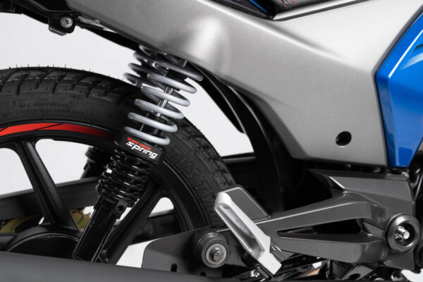 Moto 125cc Stryker origen hindú TVS fondo gris vista suspensión